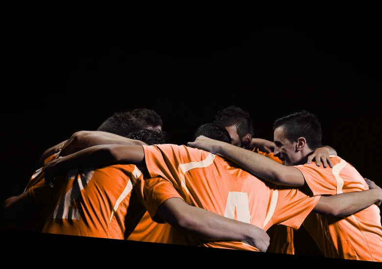 Equipo de fútbol abrazado en círculo